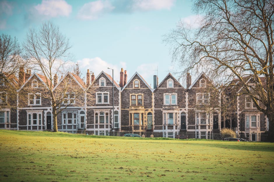 A row of Victorian terraced houses with decorative ironwork and bay windows, situated on a residential street in West Acton W3. The houses are built with brick and feature gabled roofs, with some surr